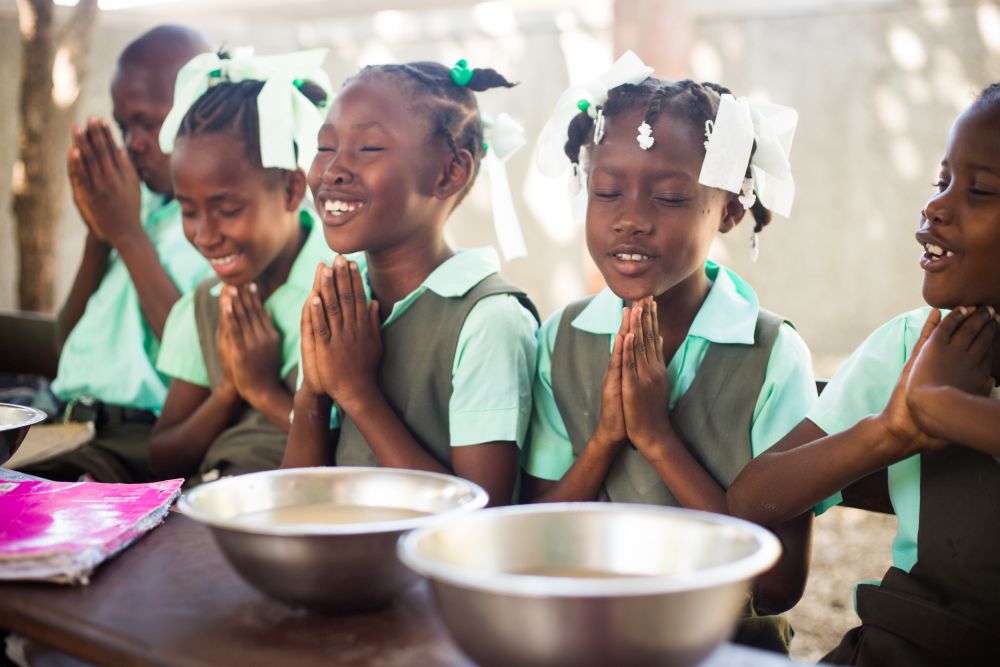 Girls praying in Haiti